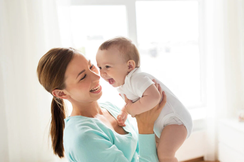 Khi mẹ cười, em bé 7 tháng cũng có thể phản ứng lại bằng cách cười theo.
